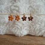 Deux paires de pampilles interchangeables Anna : une paire orange, une paire marron sur des créoles en acier inoxydable