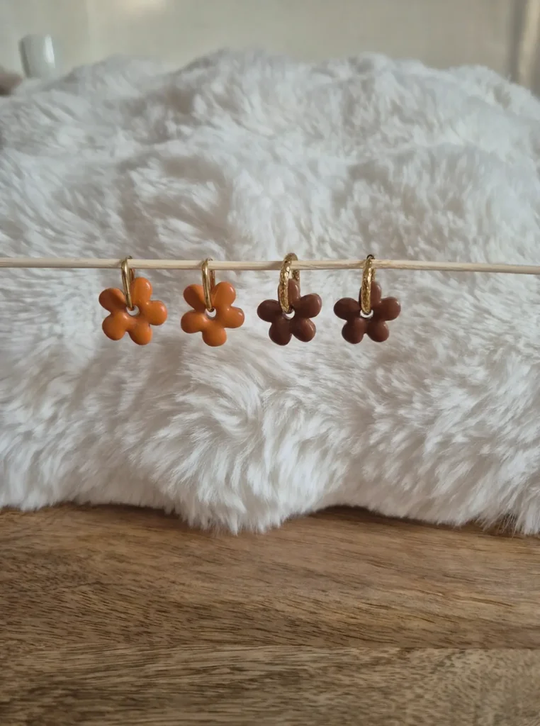 Deux paires de pampilles interchangeables Anna : une paire orange, une paire marron sur des créoles en acier inoxydable