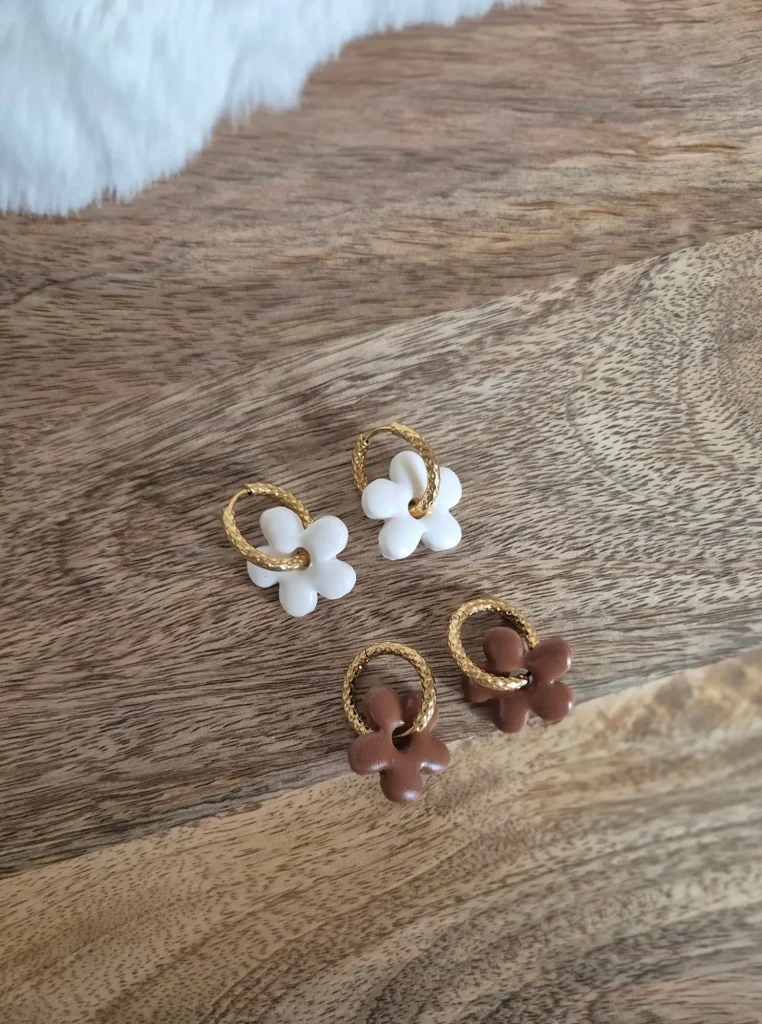 Deux paires de pampilles Anna : une blanche et une marron, posée sur un plateau en bois